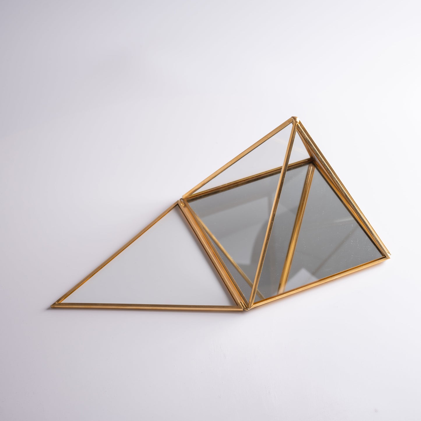 Close-up of brass pyramid box with clear glass, perfect for meditation rituals.
