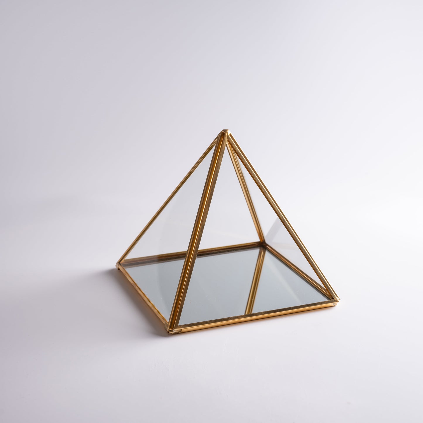Clear pyramid box placed on altar, storing crystals and sacred objects.
