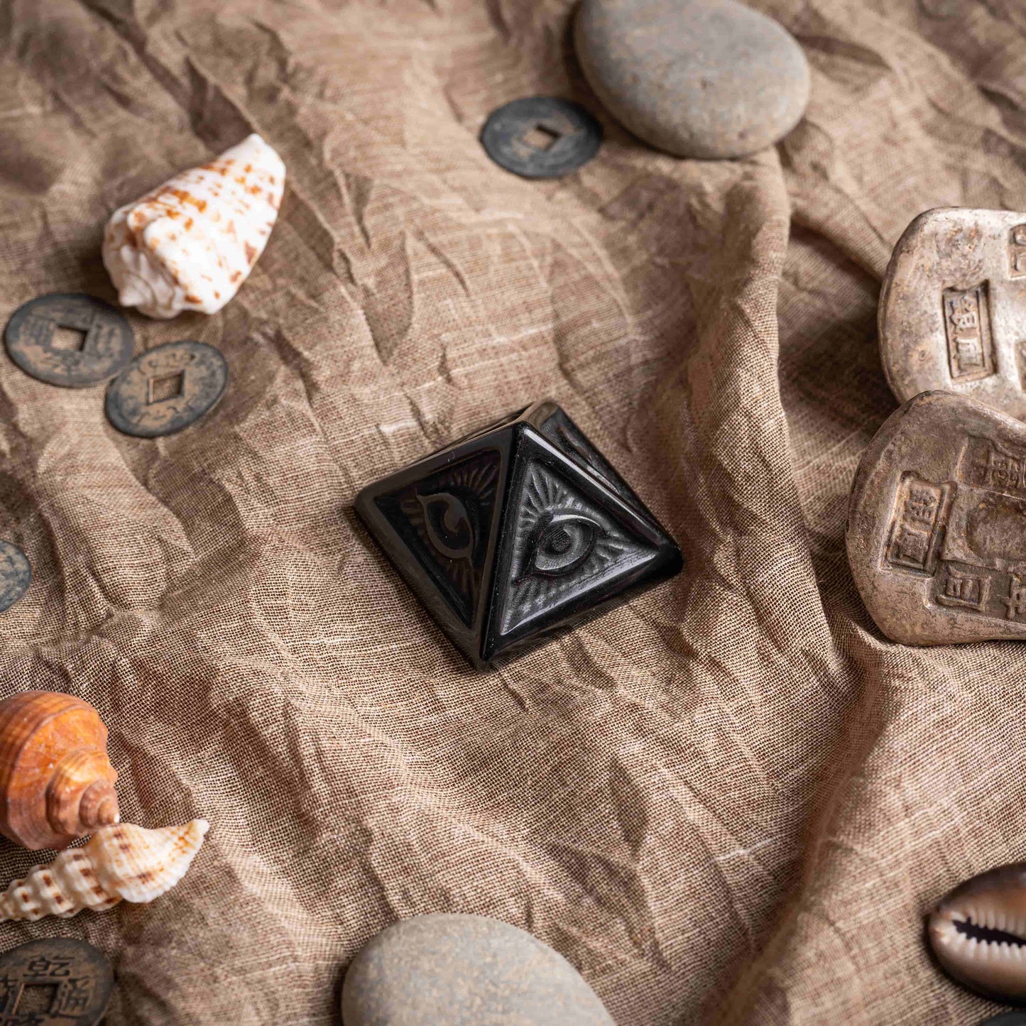 Evil eye pyramid crafted from black obsidian, sleek and mystical design.