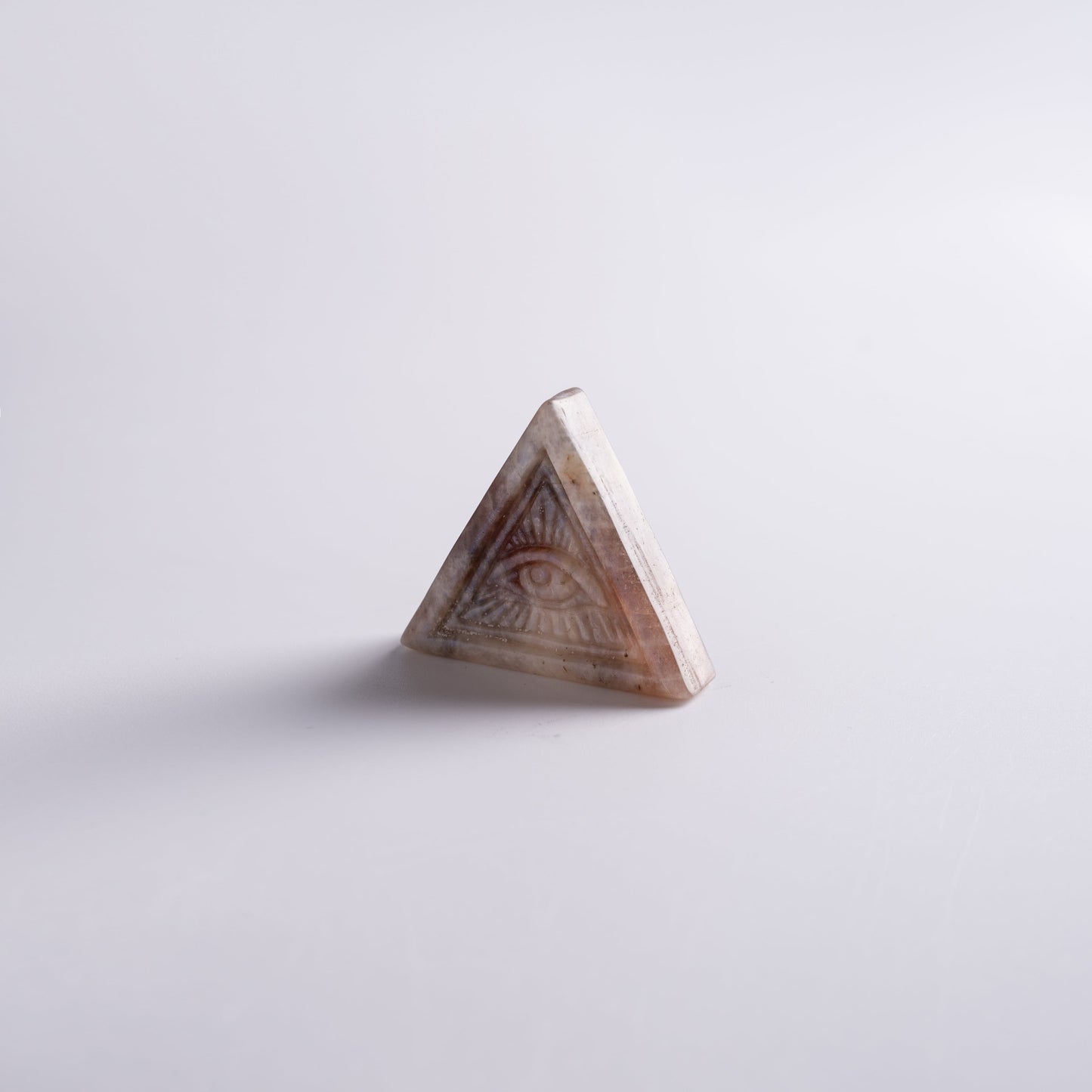 Close-up of Eye of Horus symbol engraved on natural moonstone and quartz.