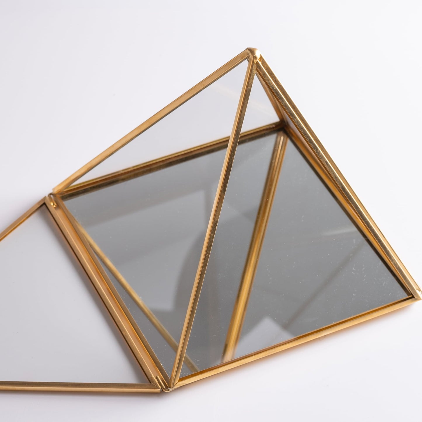 Glass pyramid box used for jewelry and crystal storage, elegant and mystical.