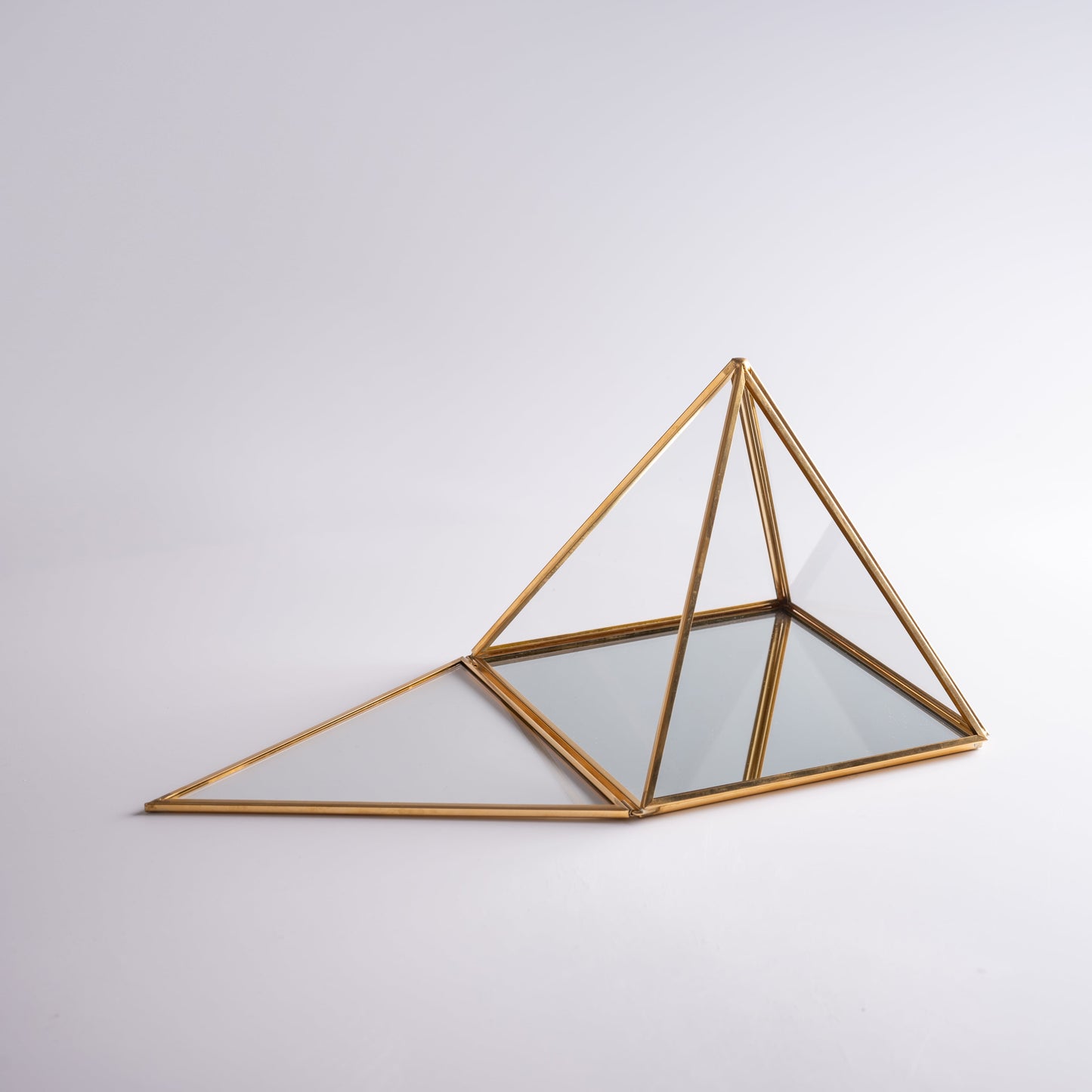 Pyramid charging glass box energizing crystals and protecting sacred space.