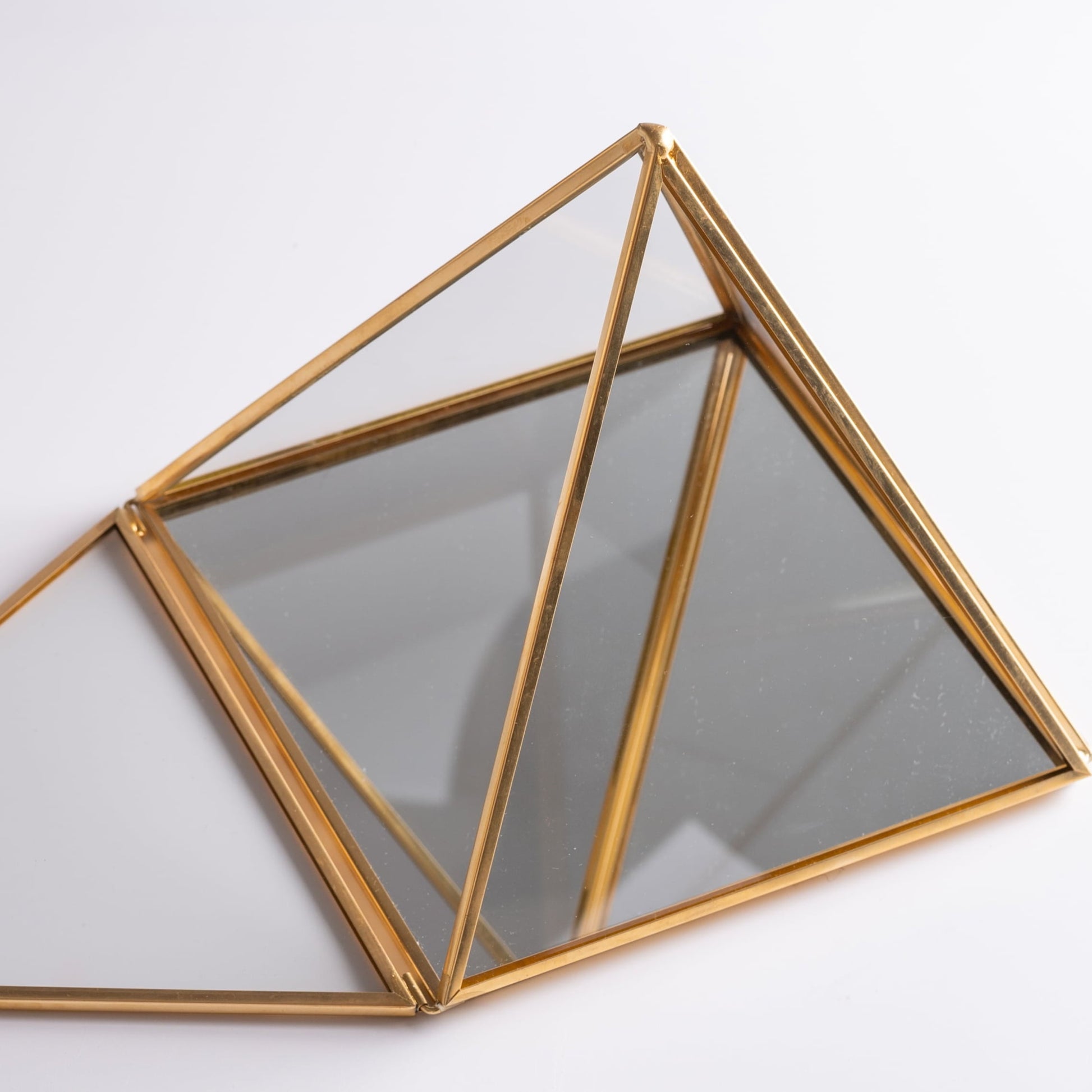 Glass pyramid box used for jewelry and crystal storage, elegant and mystical.