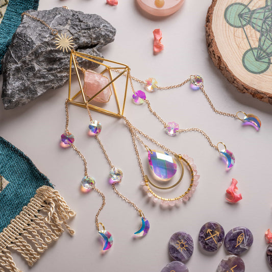 Crystal sun catcher with aurora crystals and moon gemstones hanging by a copper chain.