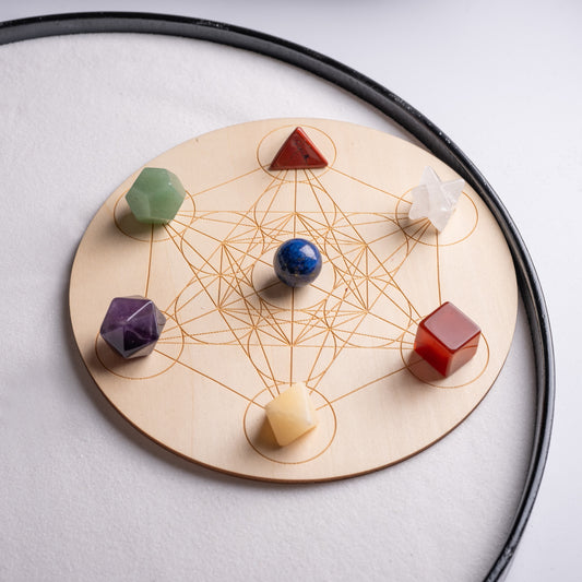 Healing crystal set with 7 chakra gemstones on wooden grid base.